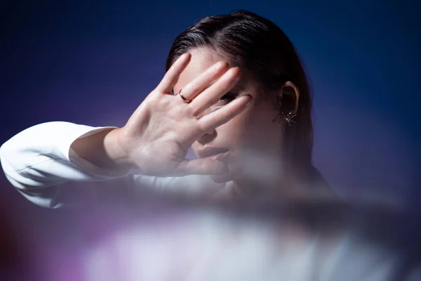 Joven mujer cubre su cara con sus manos, se esconde y dice parar. — Foto de Stock