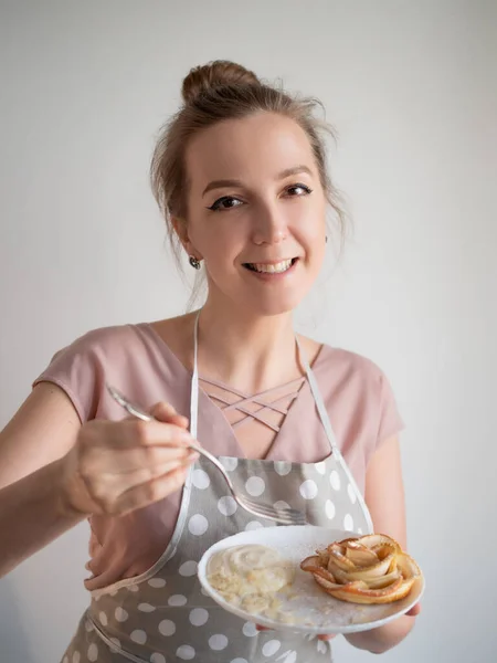 Cozinheiro chef feminino feliz no avental detém um prato de rosas de maçã — Fotografia de Stock