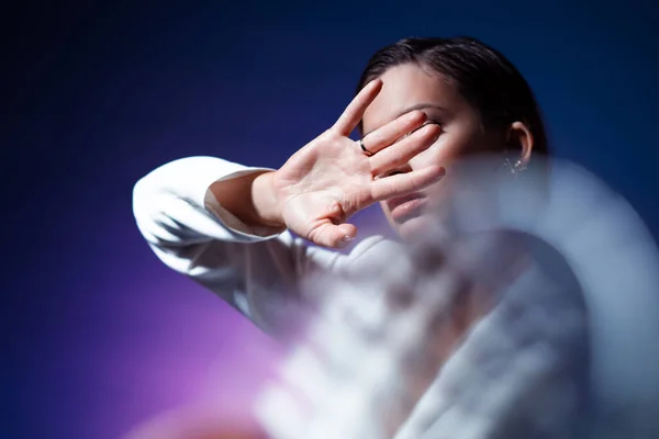 Jonge vrouw bedekt haar gezicht met haar handen, verbergt zich en zegt stop. — Stockfoto