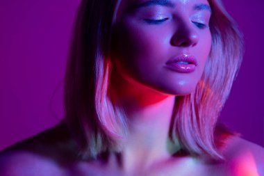 Neon ışıklı bir portre, genç ve güzel bir sarışın.