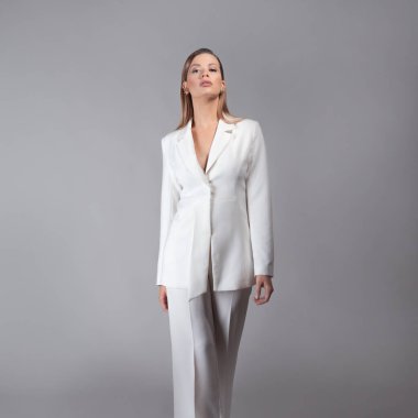 Beyaz takım elbiseli şık bir bayan, stüdyoda bir portre.