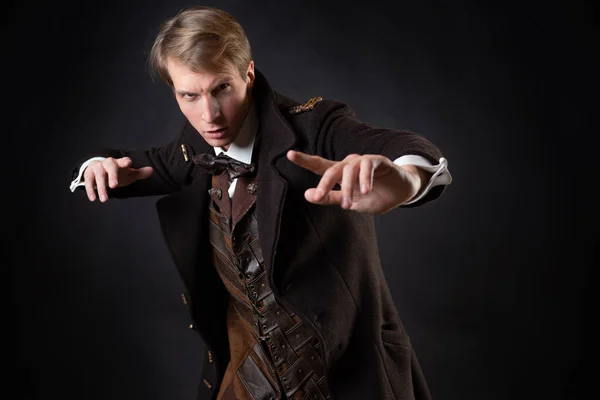 Character of the steampunk story, a young attractive man in an elegant long coat — Stock Photo, Image