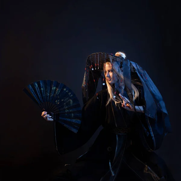 Un personaje de estilo asiático en un kimono y un sombrero de paja con cintas —  Fotos de Stock
