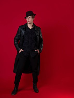 Siyah elbiseli genç, karizmatik bir adam, bir kara filmin kahramanı.,