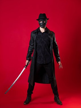 Kara film tarzında gizemli bir ninja suikastçısı. Siyah deri elbiseli bir adam.