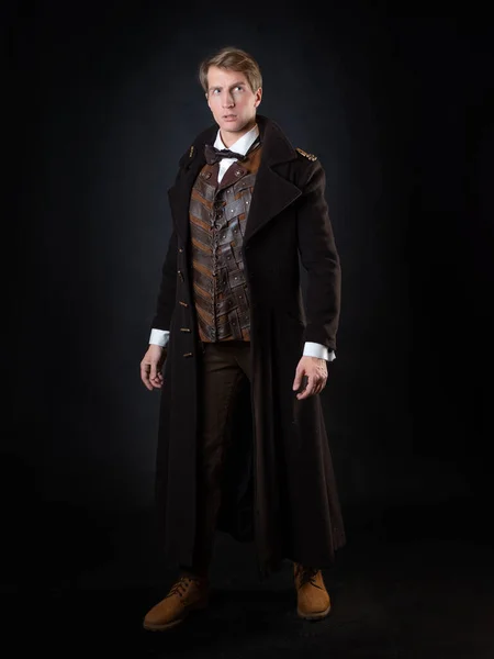 Steampunk hikayesinin karakteri, zarif, uzun paltolu genç ve çekici bir adam. — Stok fotoğraf