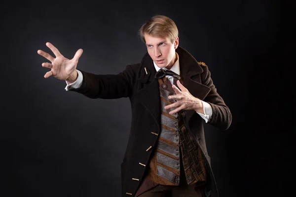 Figur der Steampunk-Geschichte, ein junger attraktiver Mann in elegantem langen Mantel — Stockfoto