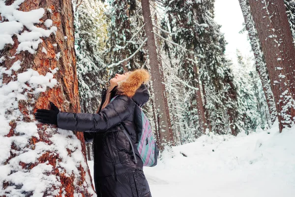 Seorang wanita tersenyum bahagia dengan pakaian hangat dengan tudung di kepalanya — Stok Foto