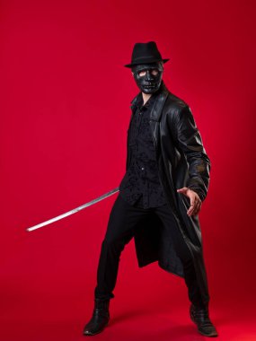 Kara film tarzında gizemli bir ninja suikastçısı. Siyah deri elbiseli bir adam.