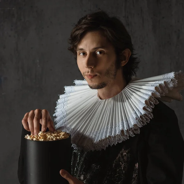 Kinobesucherin der Renaissance, ein Mann im mittelalterlichen Kragen isst Popcorn, — Stockfoto