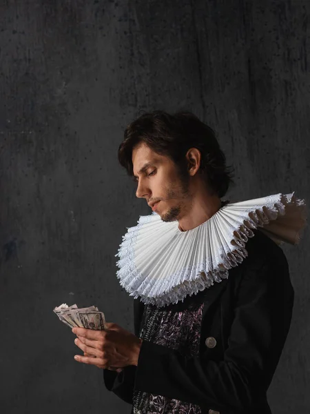 Das Honorar für die Kunst, das Konzept. Ein junger Mann in mittelalterlichem Kragen und Anzug — Stockfoto