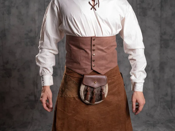 A young man in a leather kilt and a white lace-up blouse. A Scottish knight — Stock Photo, Image