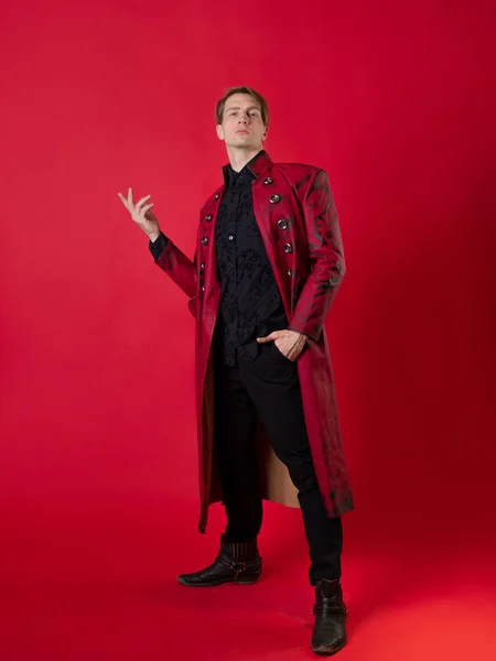 Egy felháborító fiatalember egy merész piros kabátban, vintage noir stílusban., — Stock Fotó