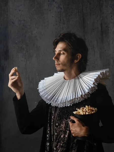Kinobesucherin der Renaissance, ein Mann im mittelalterlichen Kragen isst Popcorn, — Stockfoto