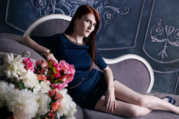 Krásná luxusní žena sedí na vinobraní gauč — Stock fotografie