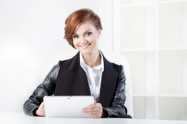 Young businesswoman with tablet in hand looking confident and smiling — Stock Photo, Image