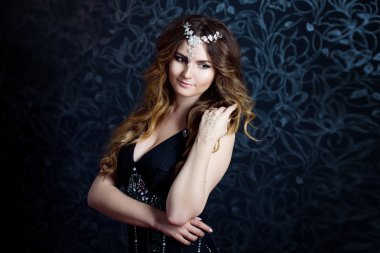 uzun kahverengi saçlı kıvrılmış, koyu arka plan güzel kız