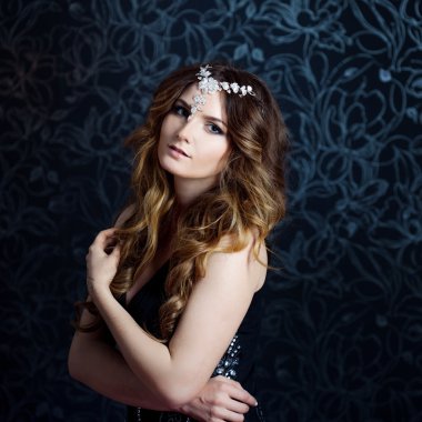 uzun kahverengi saçlı kıvrılmış, koyu arka plan güzel kız