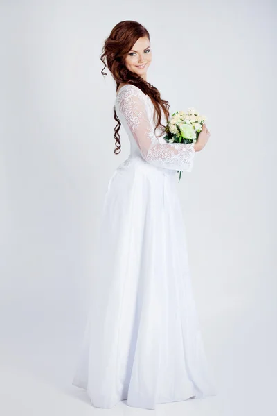 De bruid in volle groei, bruiloft jurk, houden een boeket — Stockfoto