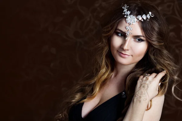 Beautiful girl  with long brown curled hair, dark background — Stock Photo, Image