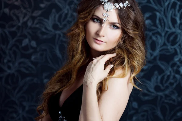 Beautiful girl  with long brown curled hair, dark background — Stock Photo, Image