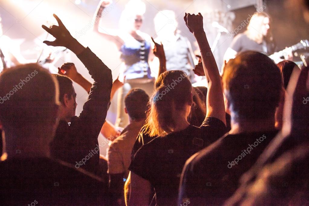 Grunge style photo, people hands raised up on musical concert
