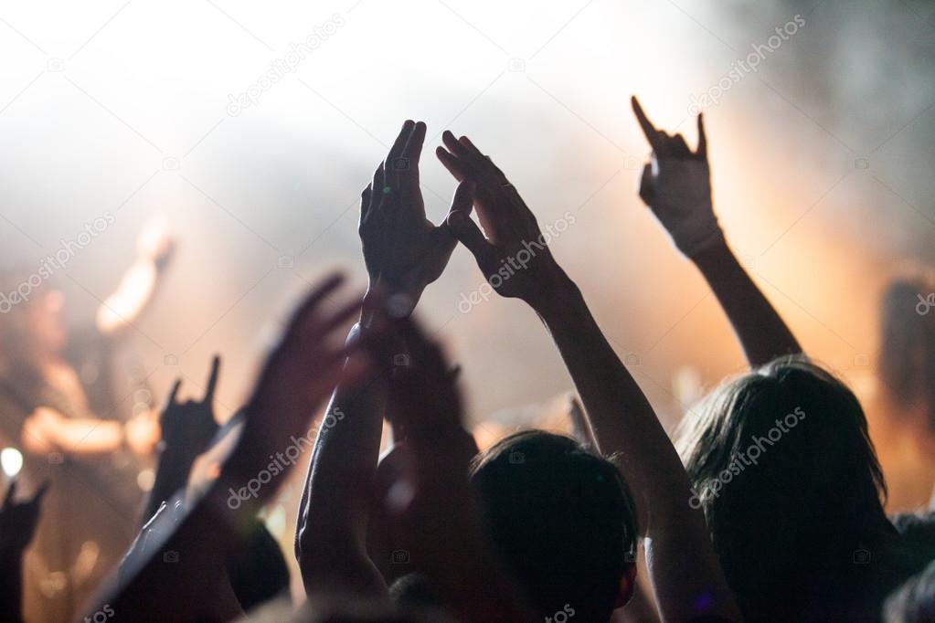 Grunge style photo, people hands raised up on musical concert
