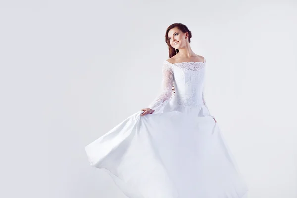 Krásná nevěsta ve svatebních šatech, bílé pozadí — Stock fotografie