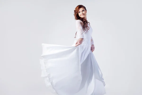 Mooie bruid in trouwjurk, witte achtergrond — Stockfoto