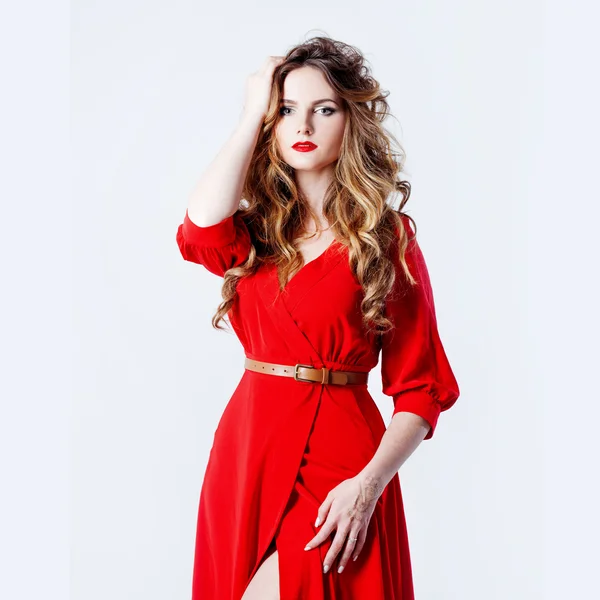 Mulher de vestido encontra-se em um fundo vermelho — Fotografia de Stock