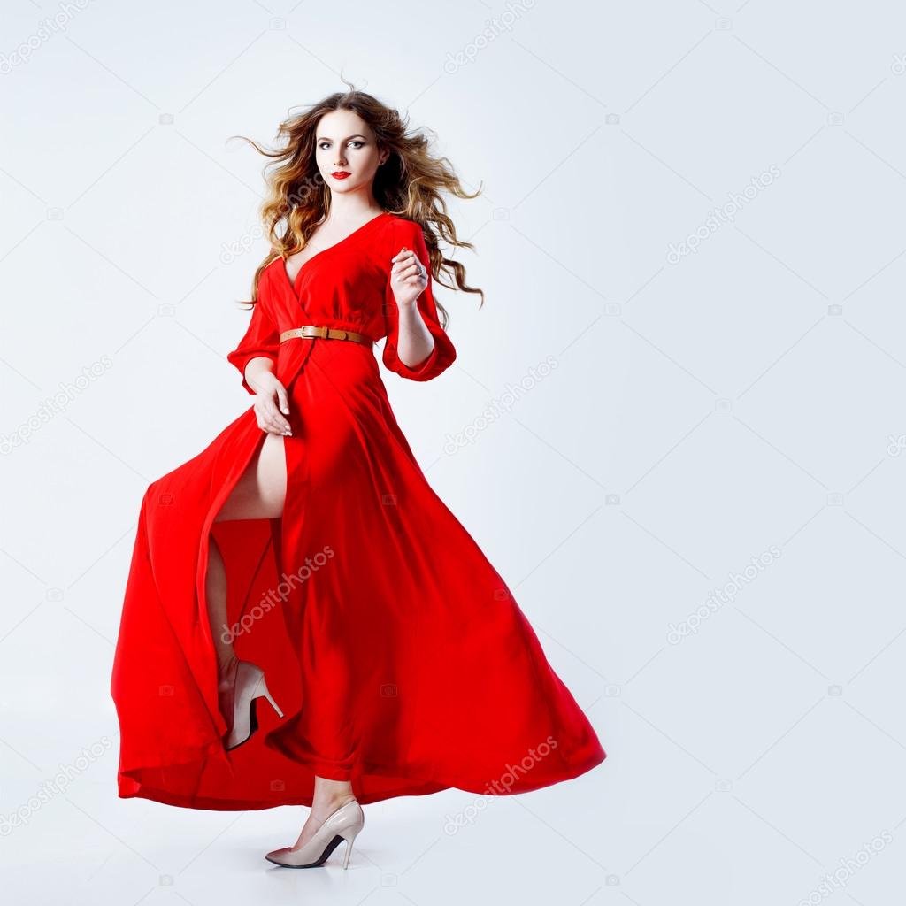 Fashion photo of young magnificent woman in red dress. Studio portrait ...