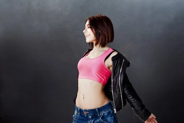 Молодая женщина хип-хоп танцовщица на заднем плане текстуры темная стена — стоковое фото
