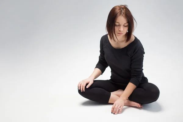 Young beautiful woman sitting in lotus position, copy space — Stock Photo, Image