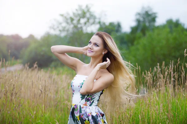 Ragazza bionda in abito su un prato — Foto Stock