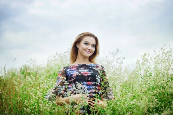 Krásy dívka venku těší přírody, blonďatá dívka v šatech na louce — Stock fotografie