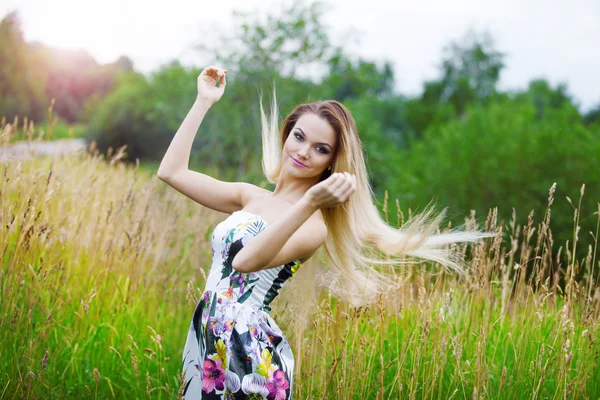 Bellezza ragazza all'aperto godendo la natura, ragazza bionda in abito su un prato — Foto Stock