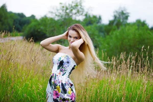 Menina beleza ao ar livre desfrutando da natureza, menina loira no vestido em um prado — Fotografia de Stock