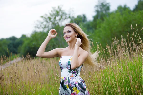 Beauty Girl Al aire libre disfrutando de la naturaleza, chica rubia en vestido en un prado — Foto de Stock