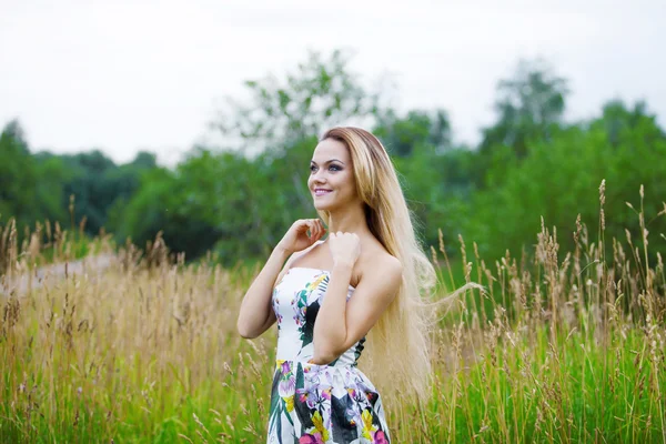 Fille blonde en robe sur une prairie — Photo