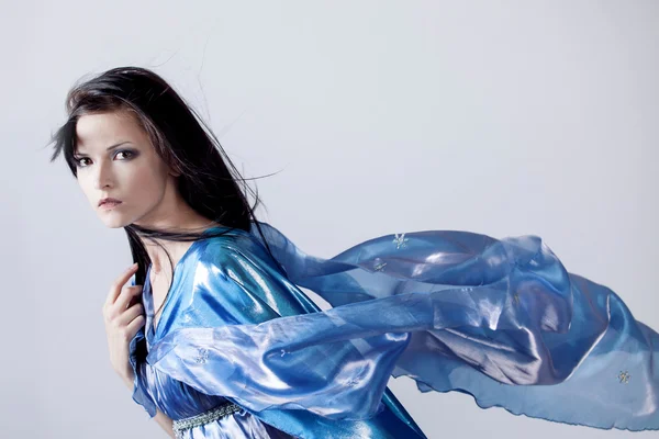 Foto de moda de la joven mujer magnífica en vestido azul. Retrato de estudio —  Fotos de Stock