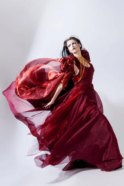 Fashion photo of young magnificent woman in red dress. Studio portrait — Stock Photo, Image