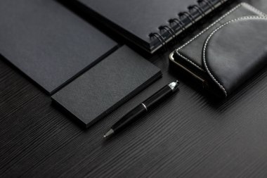 Koyu arka plan, bir kartvizit tutan el üzerinde siyah örnekler kümesini