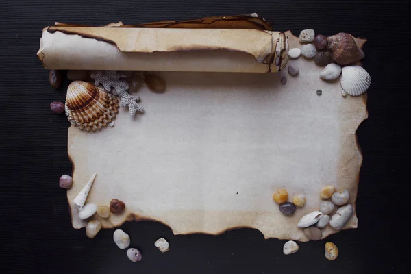 Old scroll of parchment with sea pebbles and seashells, nautical theme, place for text — Stock Photo, Image