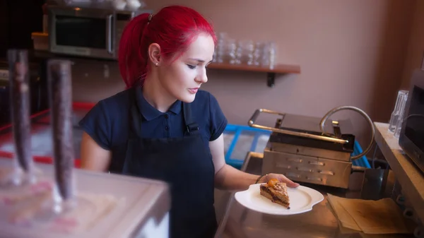 Camarera chica mostrando sus sabrosos pasteles en la cafetería — Foto de Stock