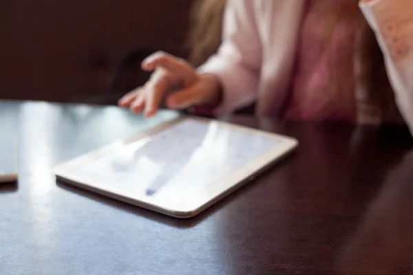 Menina trabalha no tablet digital, uma pequena profundidade de campo, foco suave — Fotografia de Stock