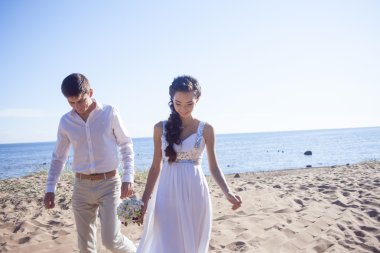 Kumlu bir plaj üzerinde çalışan sadece evli mutlu çift