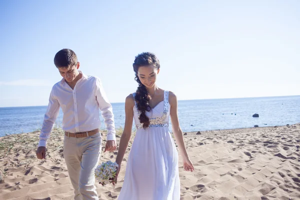 Prostě šťastný manželé běží na písečné pláži — Stock fotografie