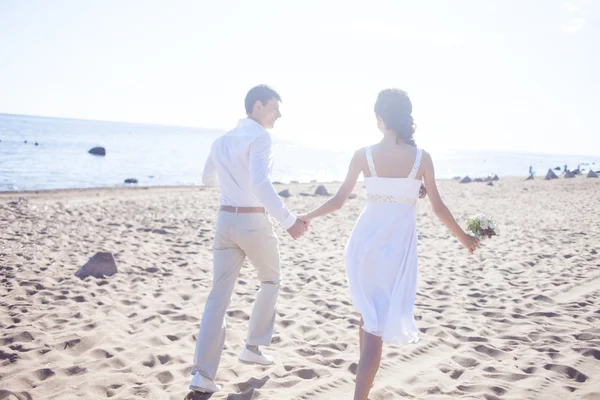 Net getrouwd gelukkige paar draait op een zandstrand — Stockfoto