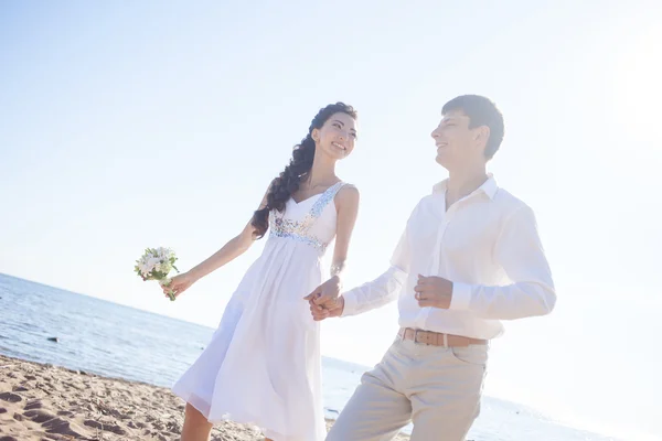 Just married happy couple running on a sandy beach — Stock Photo, Image