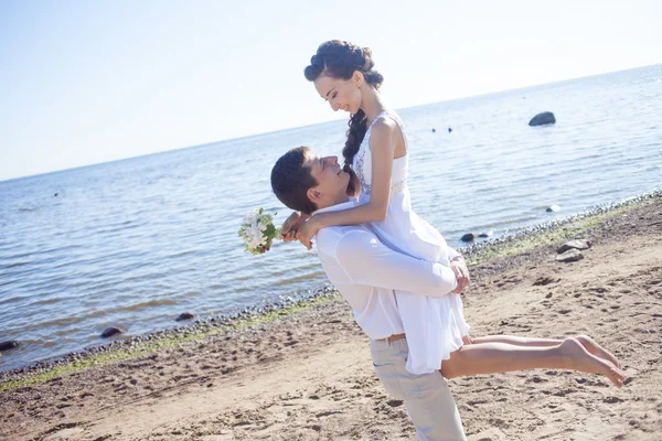 Net getrouwd gelukkige paar draait op een zandstrand — Stockfoto